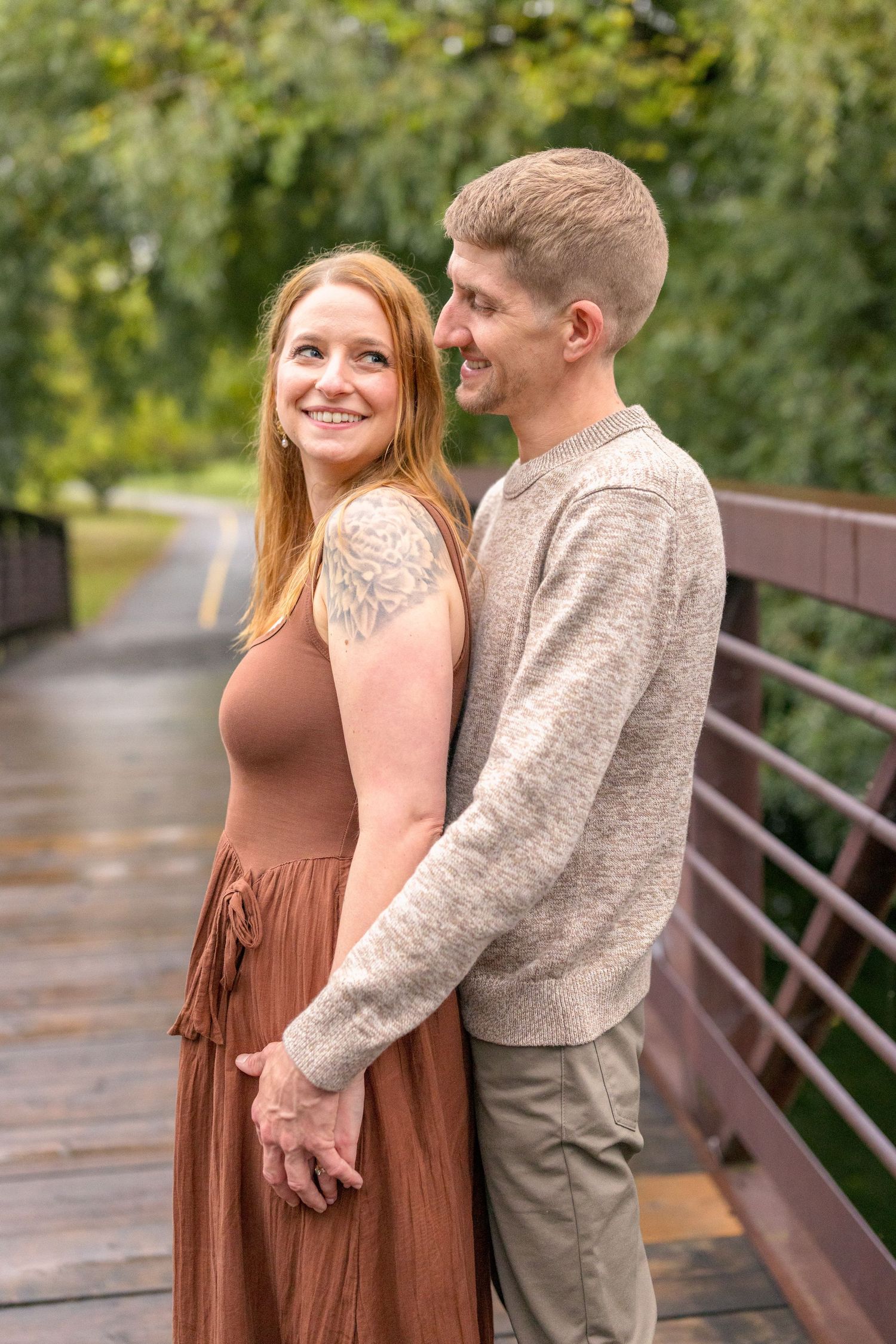 Sweet candid moments captured on wooden bridge walkway during autumn. Ottawa Wedding Photographer