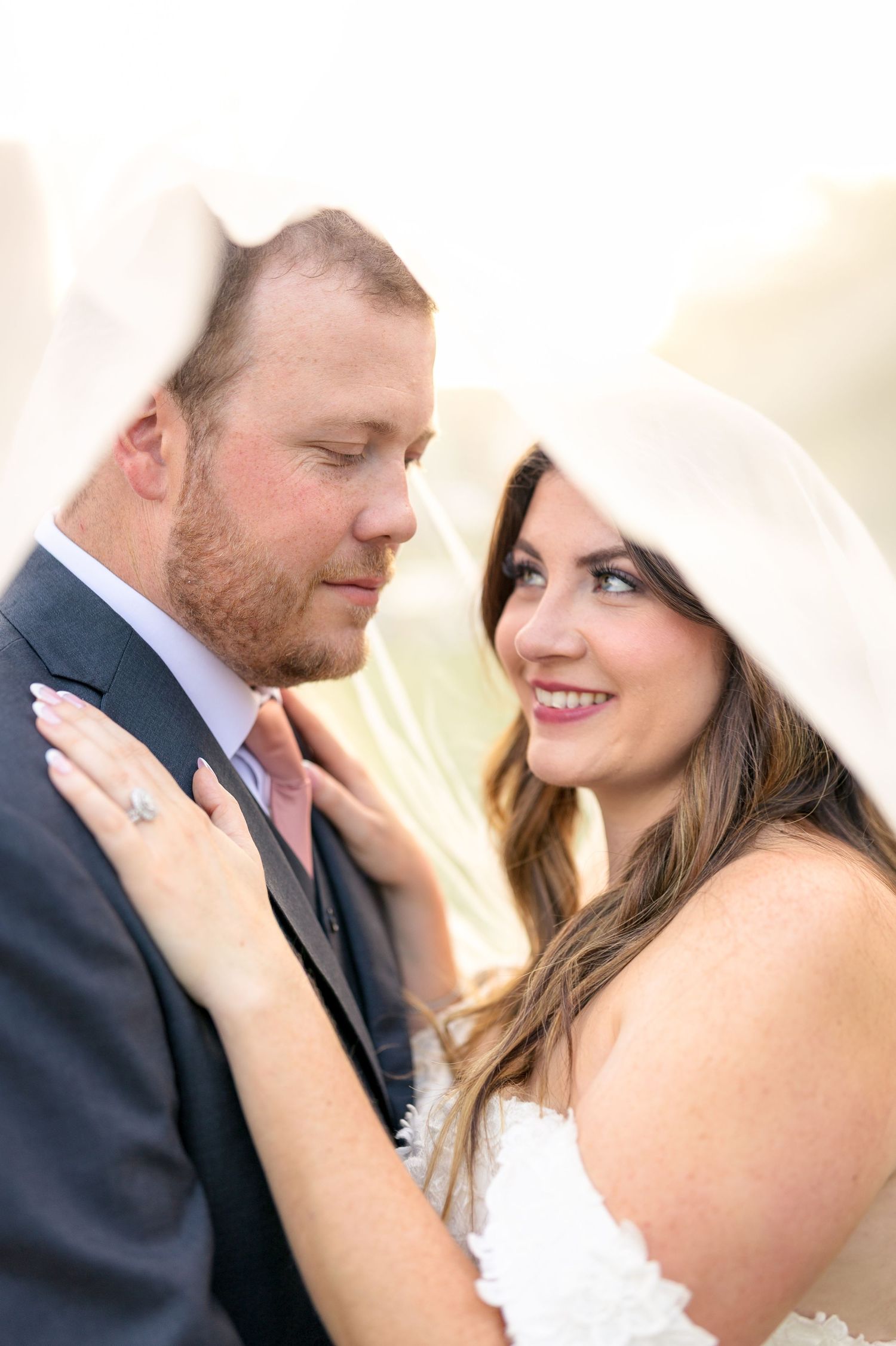 Romantic wedding couple shares intimate moments in soft sunlit portraits showing tender affection and joy. Ottawa wedding photographer