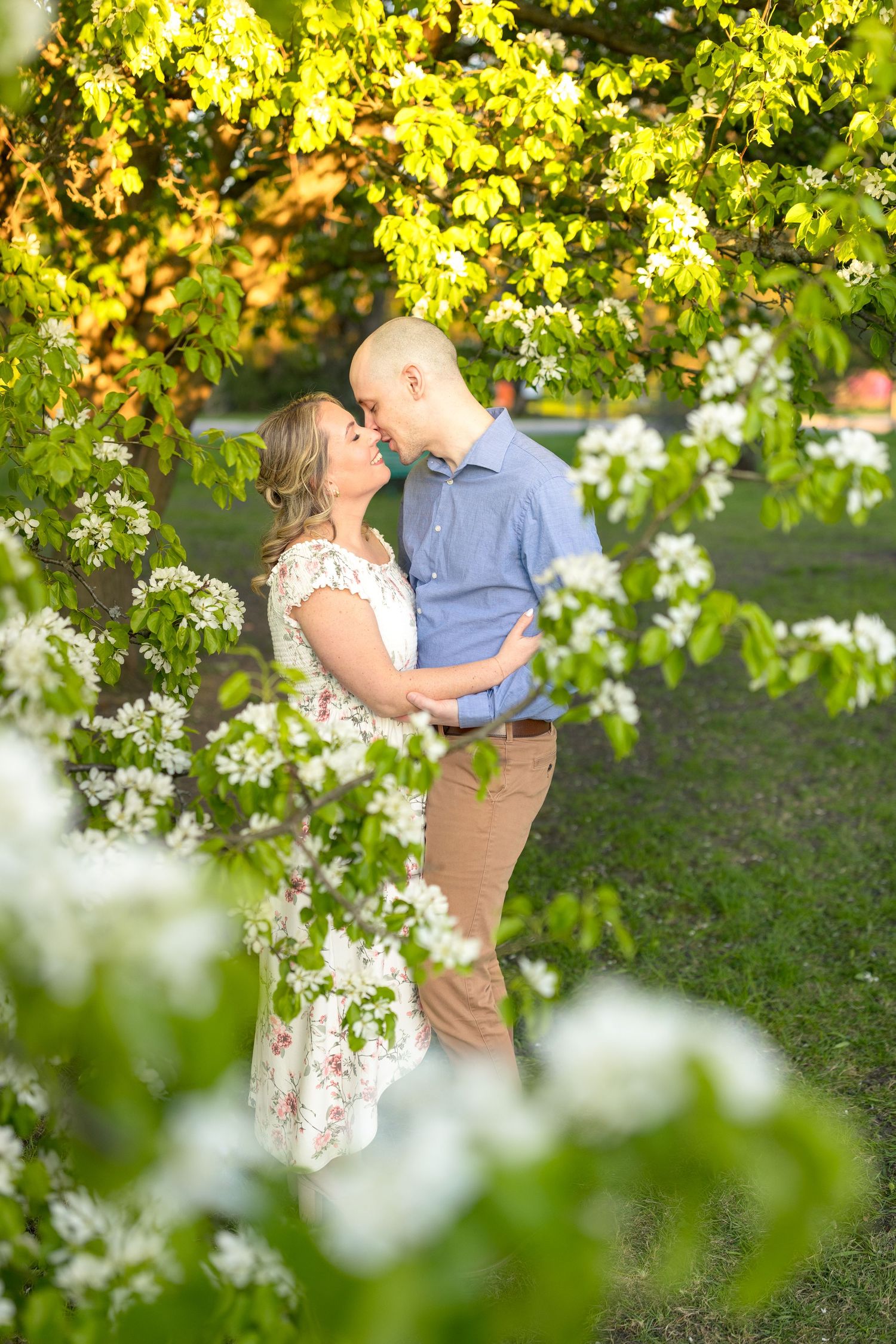 A romantic spring portrait with white flowers and green leaves framing the couple. Ottawa Wedding Photographer