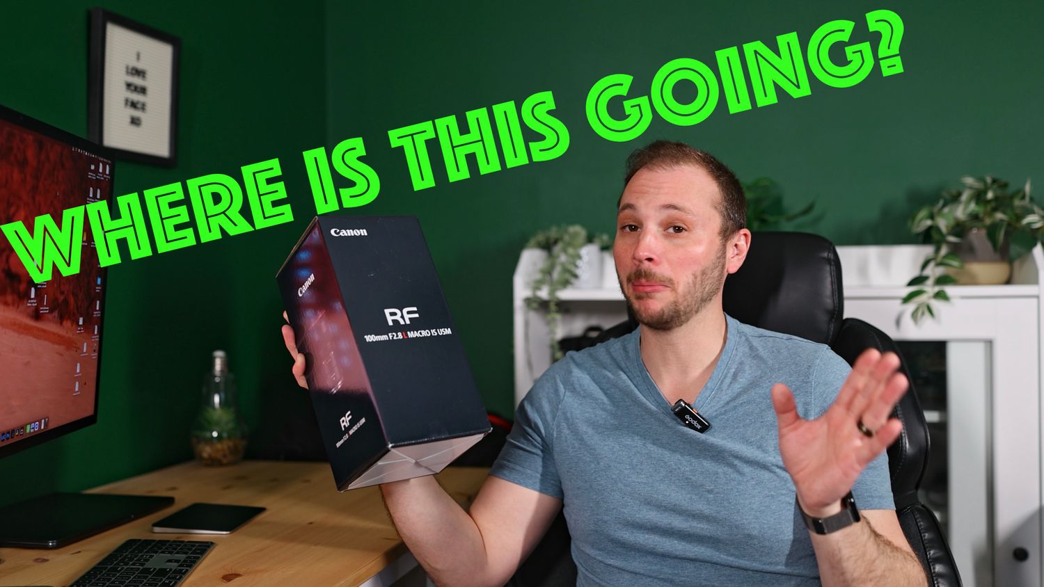Man holding Canon RF remote booster box with text overlay asking WHERE IS THIS GOING at a home desk setup.