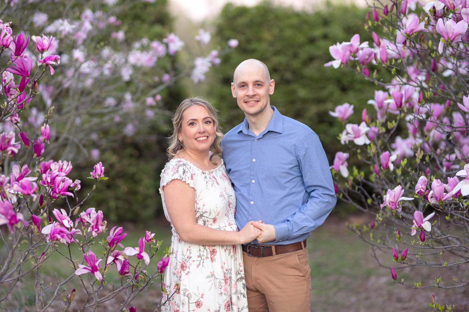 Couple dancing and laughing together surrounded by blooming pink magnolia trees. Ottawa Wedding Photographer
