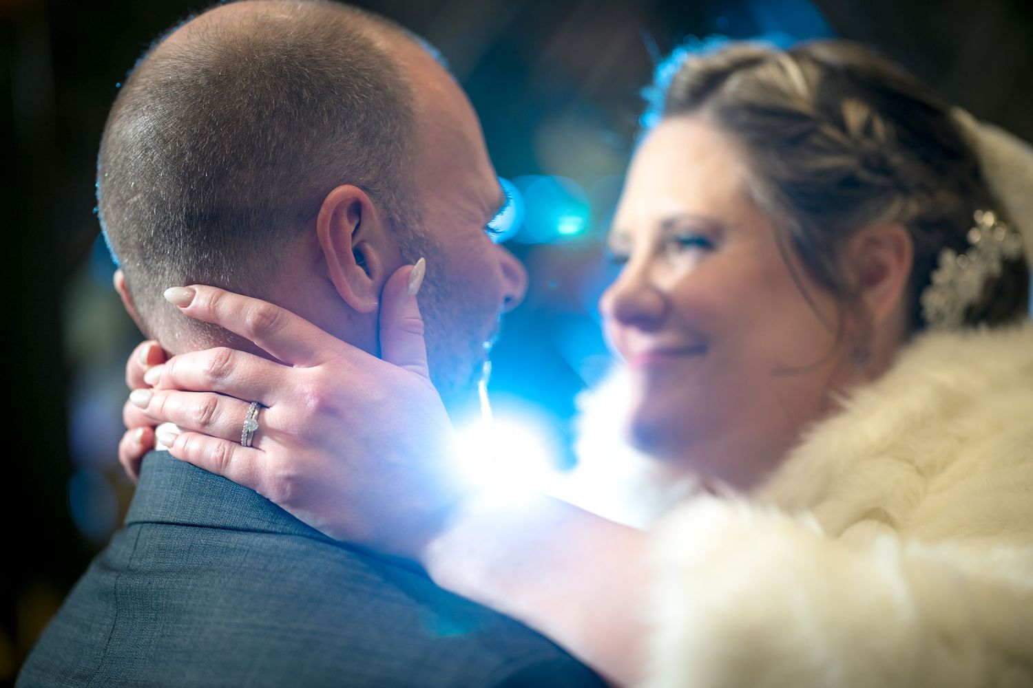 A romantic silhouette of a couple sharing a kiss under blue lighting at a wedding reception. Ottawa Wedding Photographer