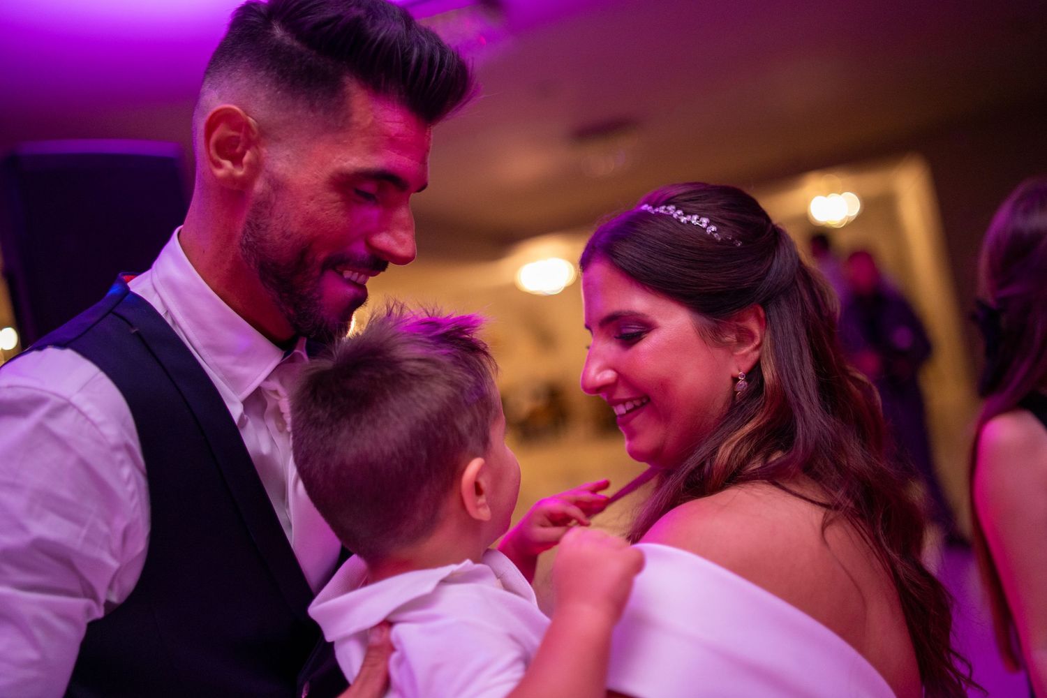 Noivos com criança durante festa de casamento na Quinta da Lage, Santo Tirso, momento emotivo em família.