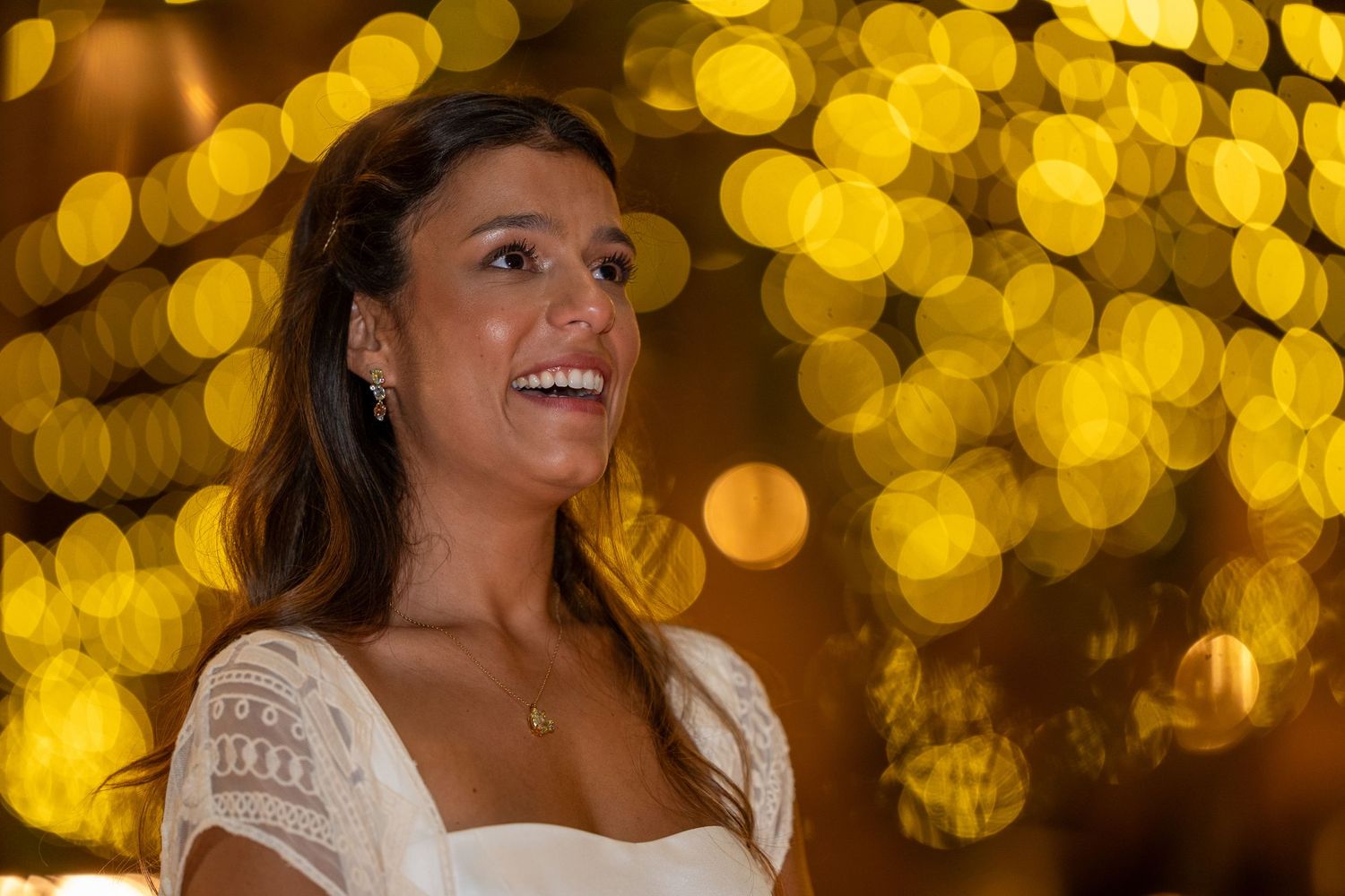 Retrato da noiva com iluminação decorativa ao fundo na Quinta Alferes de Castro, ambiente romântico e elegante.
