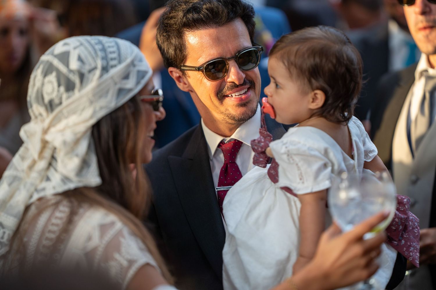 Noivo com criança durante cocktail de casamento na Quinta Alferes de Castro, momento espontâneo entre convidados.