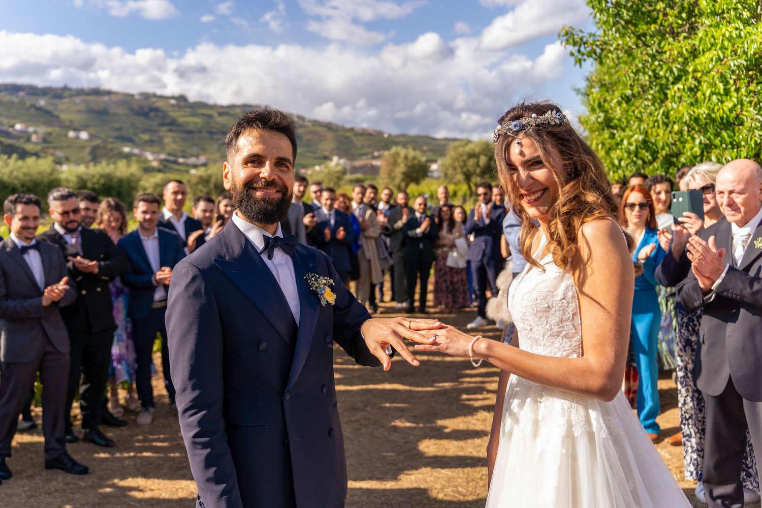 Noivos durante cerimónia de casamento nas vinhas da Quinta da Pacheca, no Douro, rodeados por convidados ao ar livre