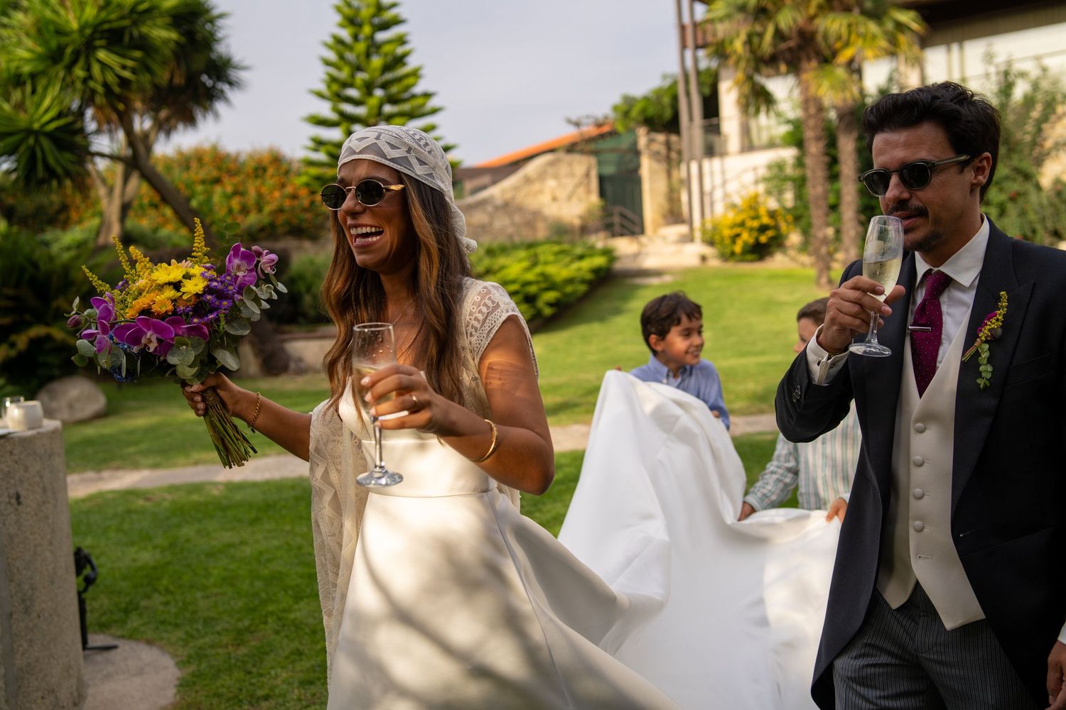 Noivos a caminhar durante casamento na Quinta Alferes de Castro, momento descontraído ao ar livre com convidados.