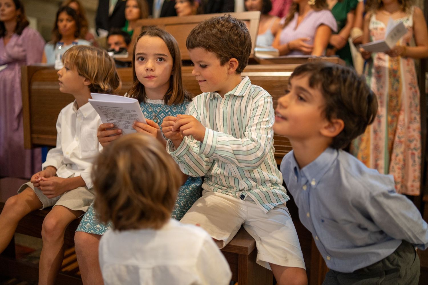 Crianças durante cerimónia de casamento na Igreja Paroquial de Leça da Palmeira, ambiente descontraído entre convidados.