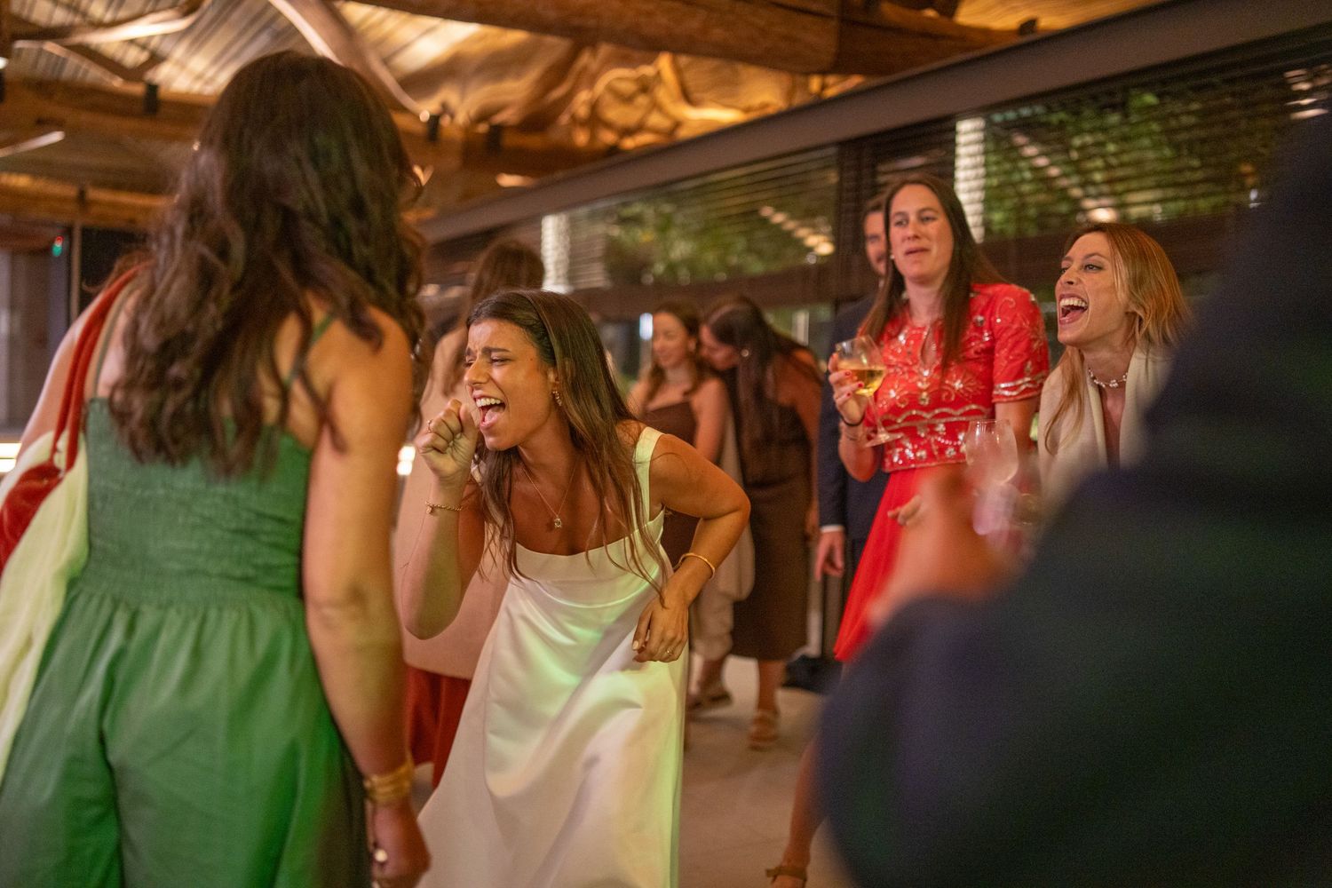 Noiva e convidadas a dançar durante festa de casamento na Quinta Alferes de Castro, ambiente animado e descontraído na pista.