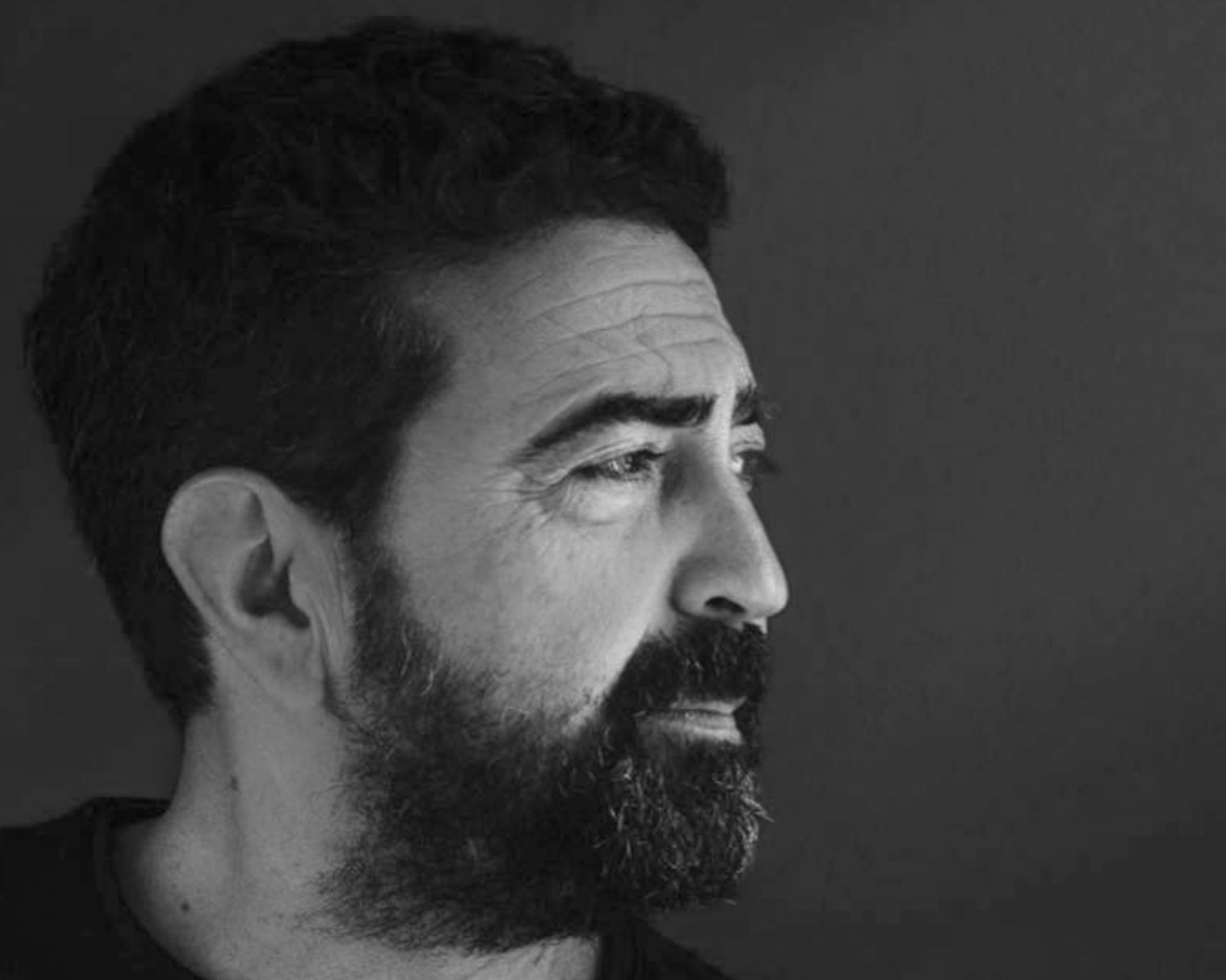 Retrato do fotógrafo de casamento Paulo Calheiros, estilo editorial em preto e branco com luz dramática.