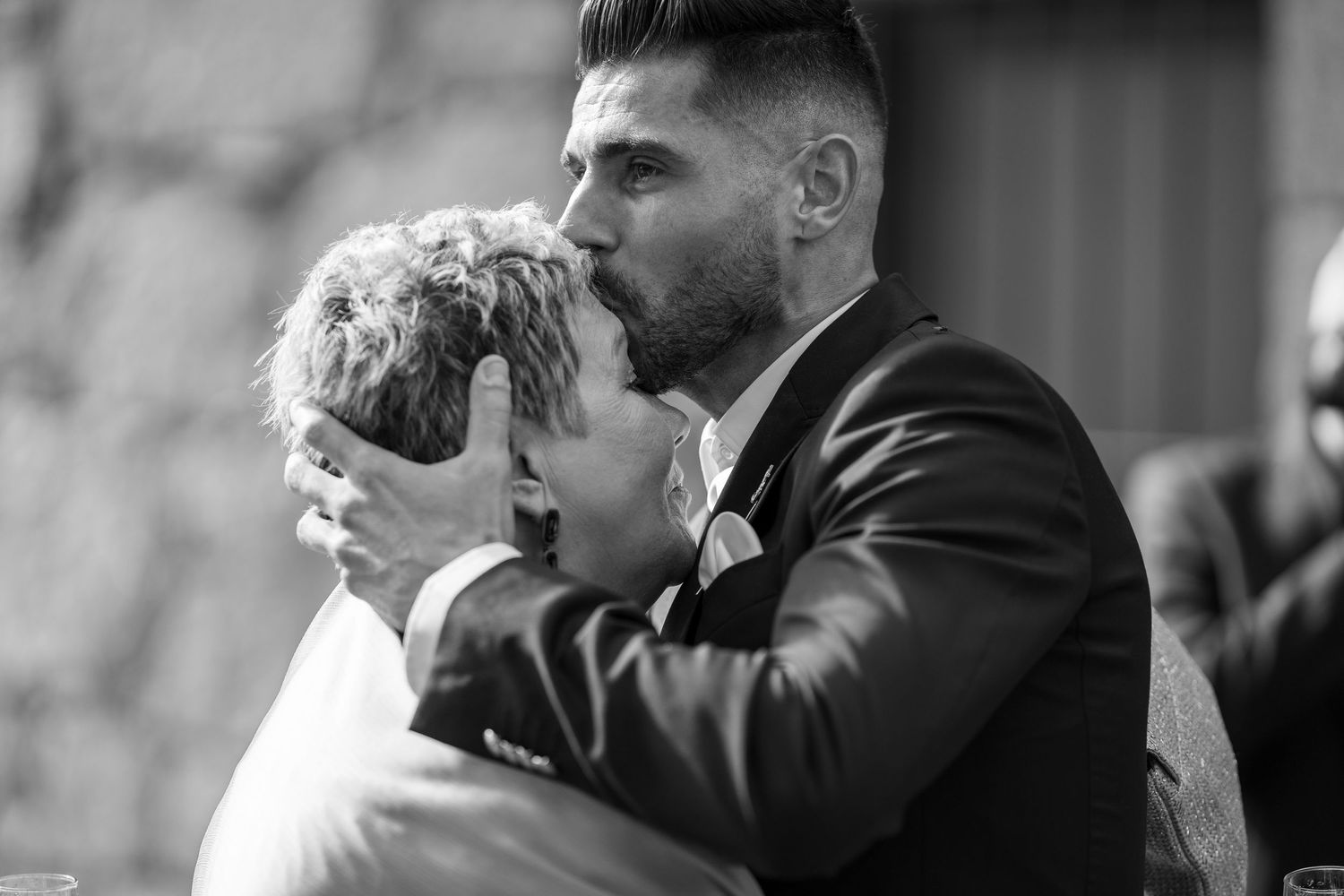 Momento emotivo durante preparação do casamento, beijo de carinho entre familiares antes da cerimónia.