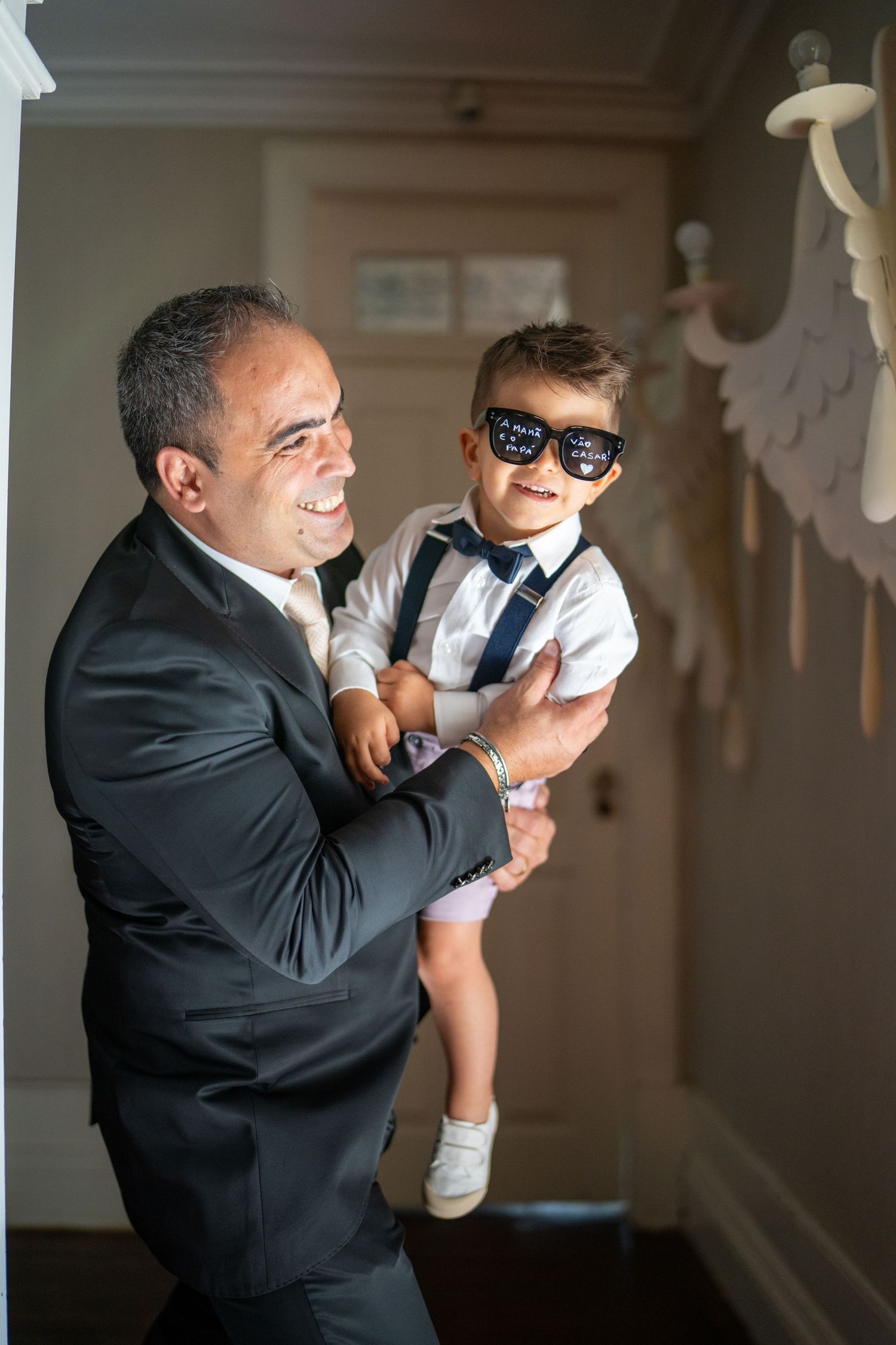 Convidado com criança durante casamento na Quinta da Lage, em Santo Tirso, momento espontâneo em família.