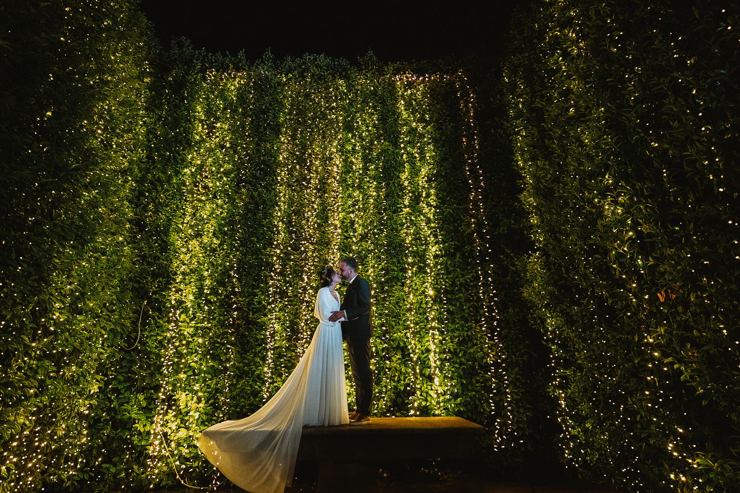 Noivos em jardim com luz dramática, fotografia de casamento artística e envolvente, na Casa do Ribeirinho, em Matosinhos.