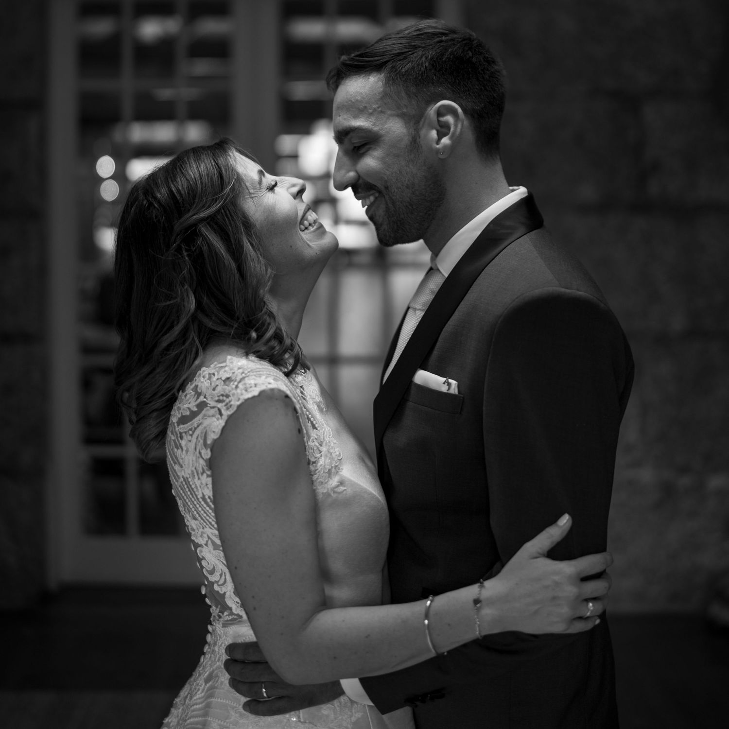 Beijo espontâneo dos noivos durante sessão de casamento, retrato a preto e branco com emoção e intimidade.