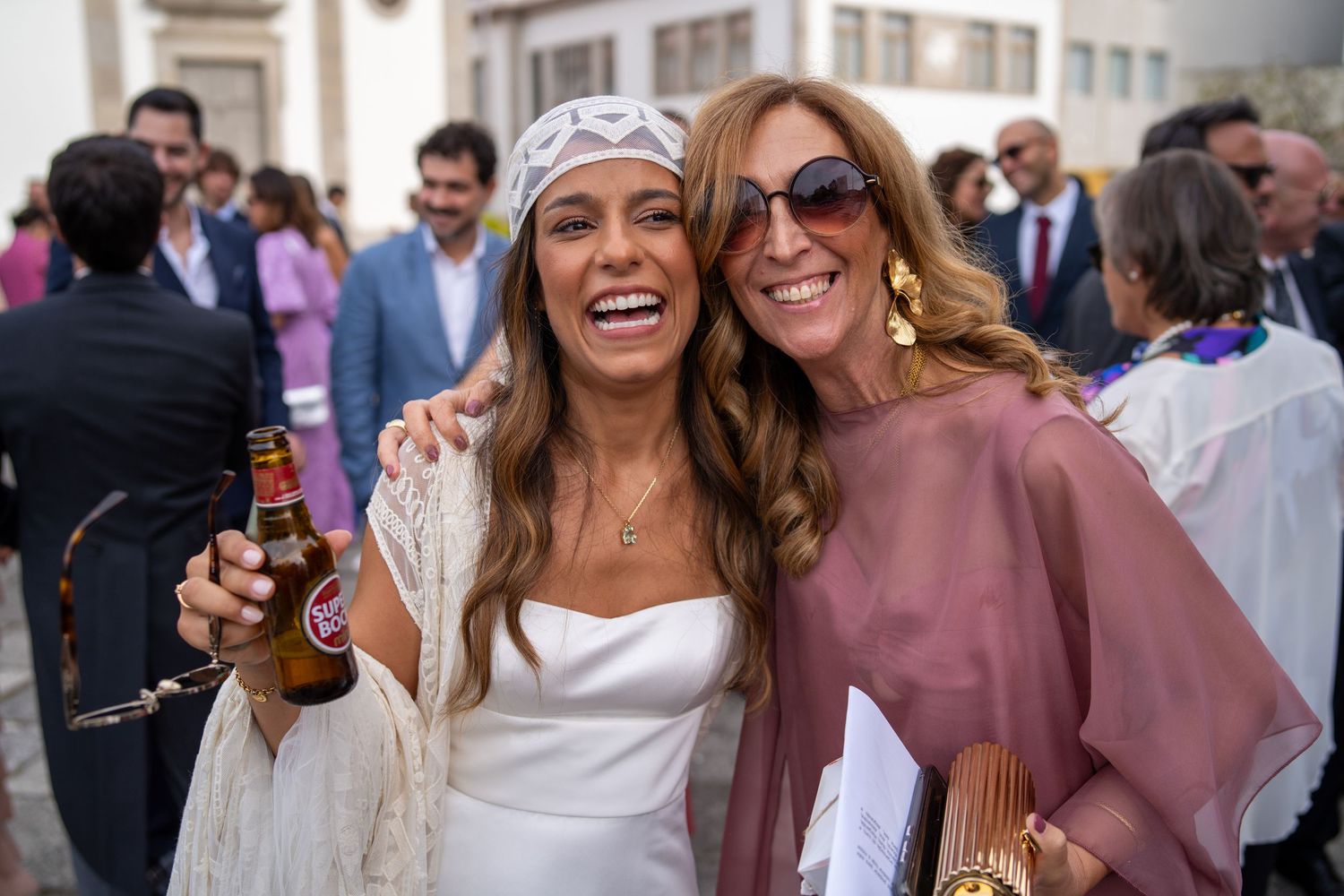 Noiva com convidada após cerimónia na Igreja Paroquial de Leça da Palmeira, momento alegre durante o casamento.