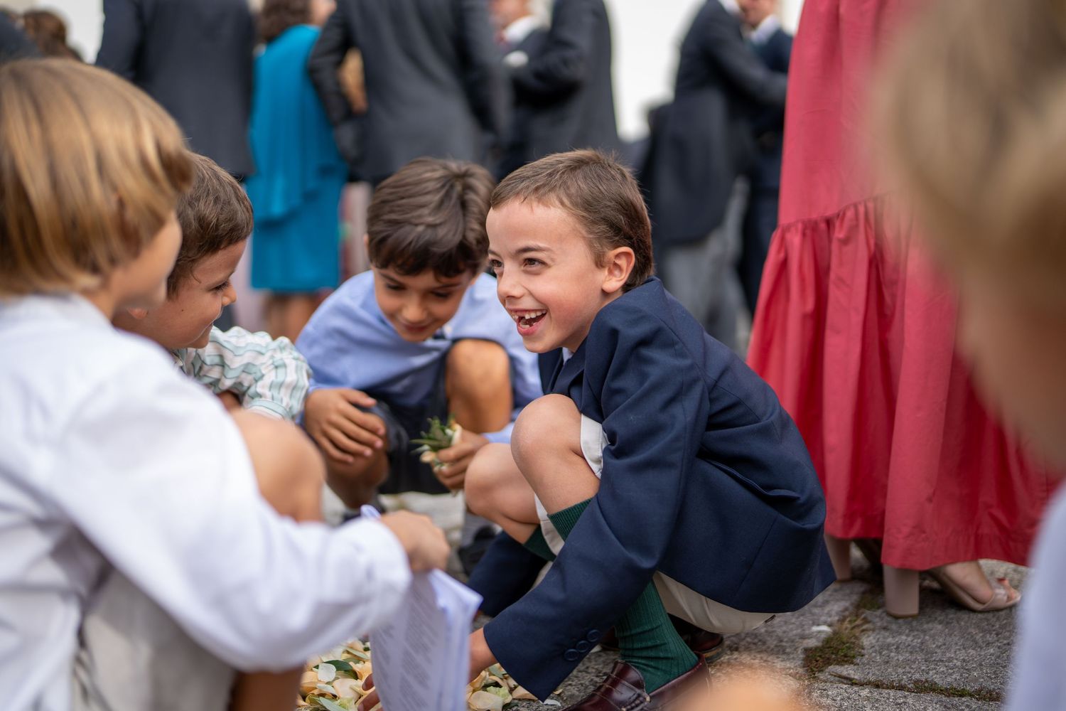 Crianças a brincar durante casamento na Igreja Paroquial de Leça da Palmeira, momento espontâneo entre convidados.