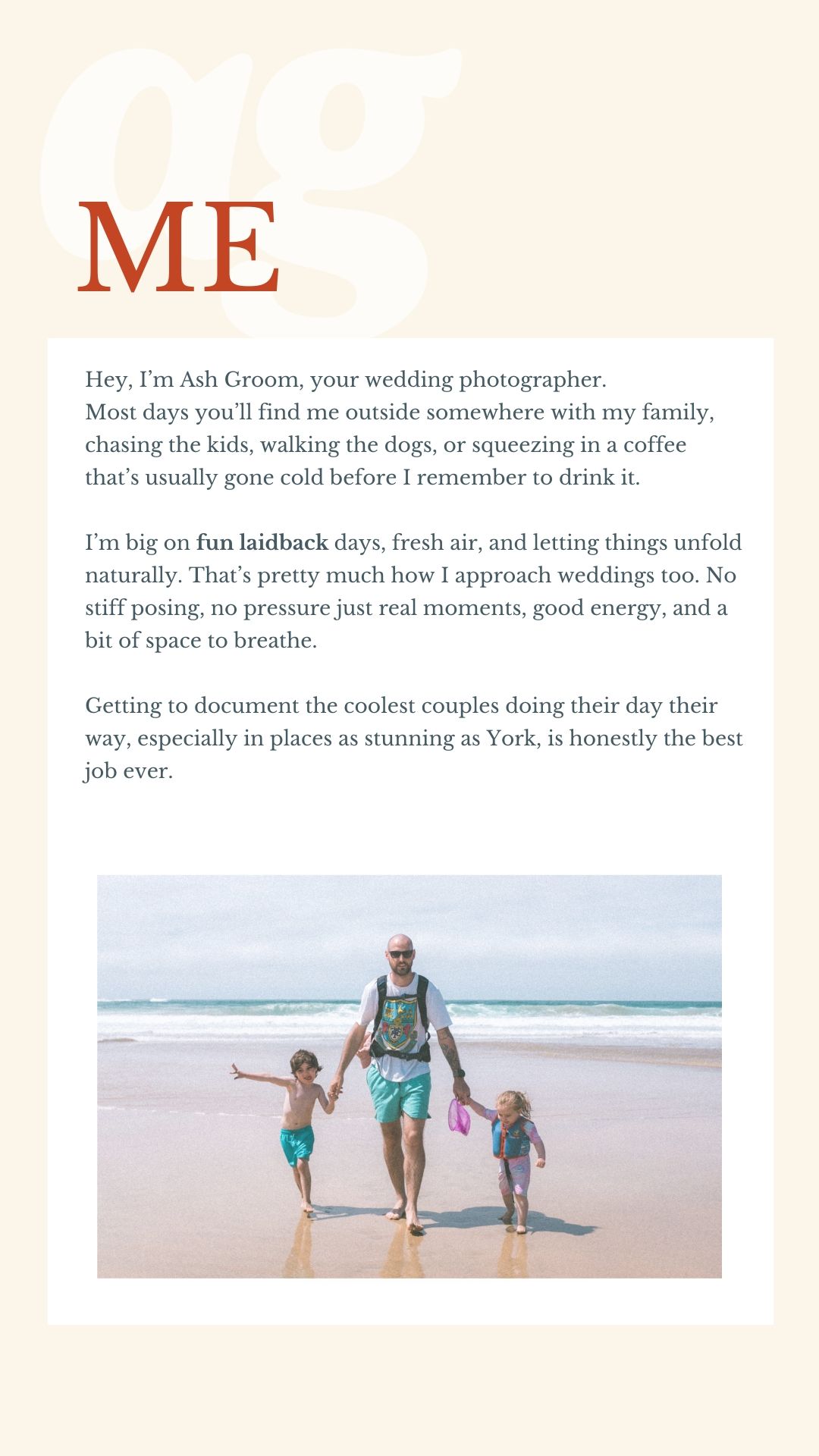 Wedding photographer Ash Groom walks on a sandy beach with two young children holding hands near the ocean shoreline.