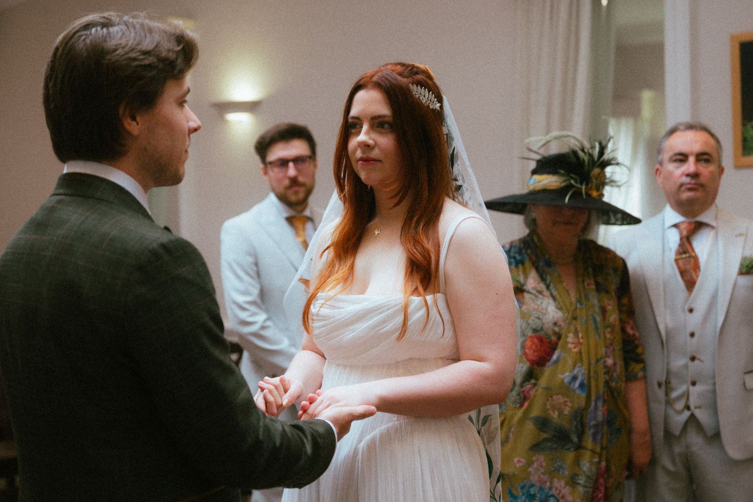 Bride with red hair exchanges vows with groom at intimate wedding ceremony.