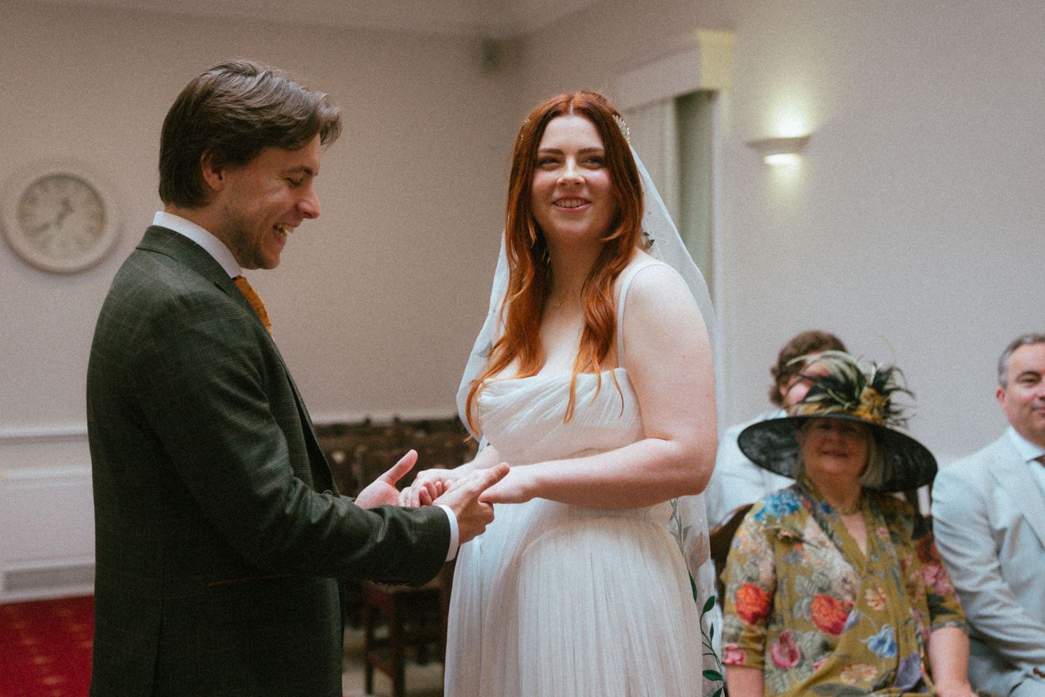 Couple exchanging rings during a wedding ceremony in a registry office.