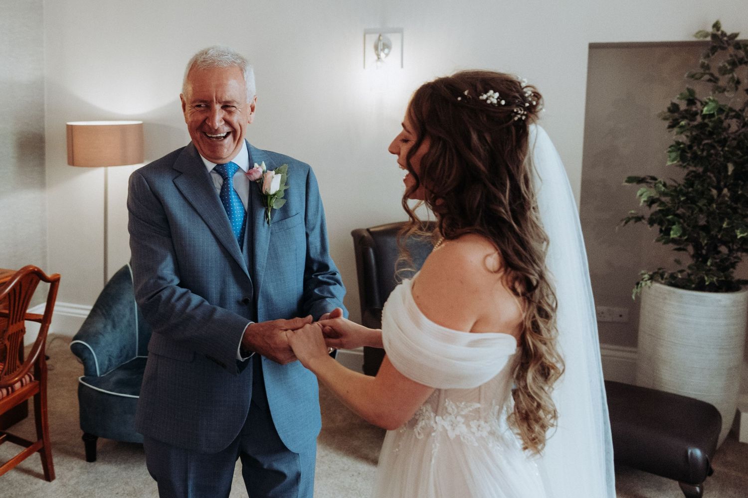 Smiling father of the bride sharing a tender first look moment with his daughter.