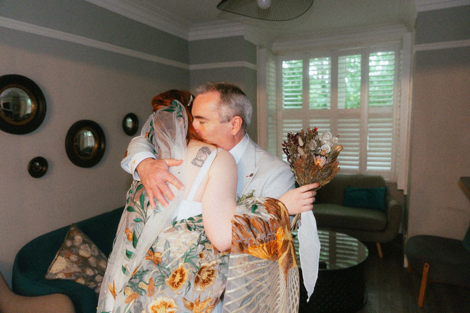 Bride and groom share a warm embrace indoors during wedding celebrations.