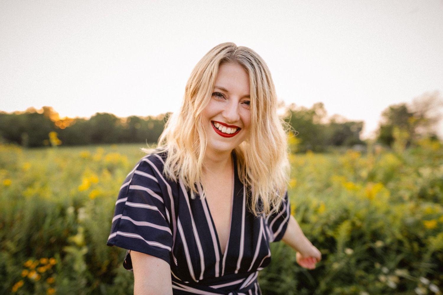 Sara Baillies, of Sara Baillies Photography, smiling in a field