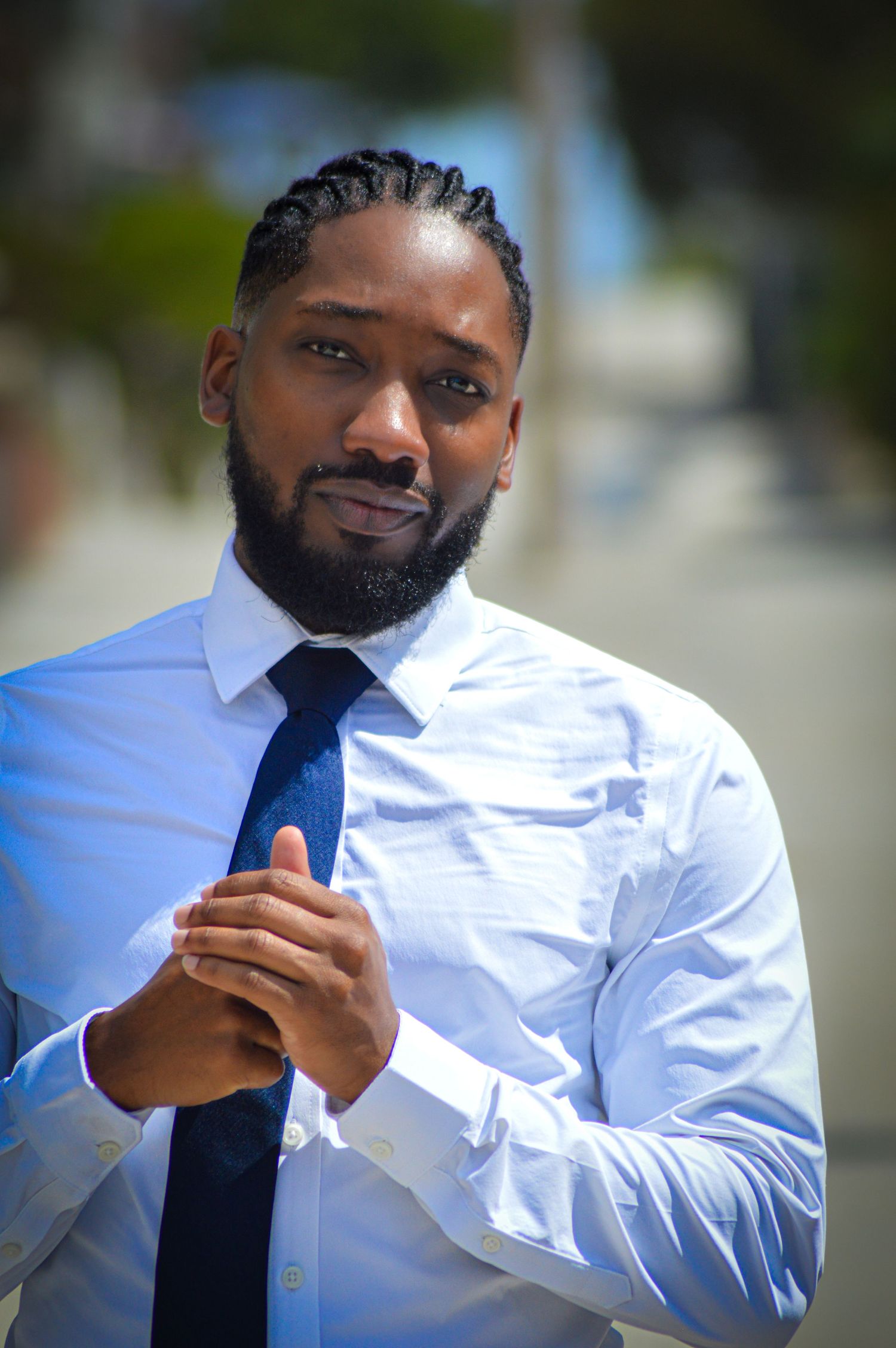 Professional in a crisp white dress shirt and blue tie adjusts his collar in a sequence of photos outdoors.