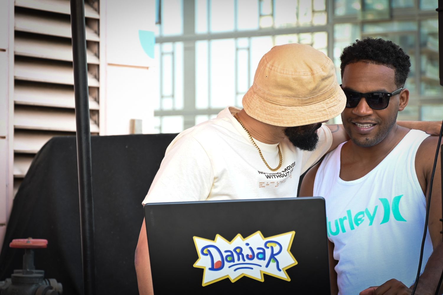 A group of people standing together in a casual setting wearing summer attire and sunglasses.