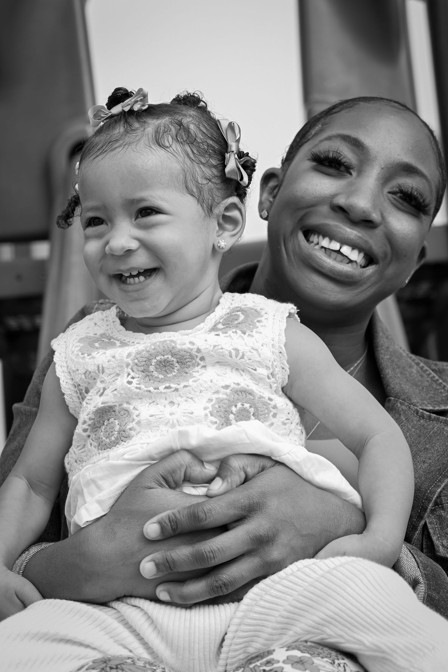 A joyful black and white portrait of a parent and young child with matching bright smiles.