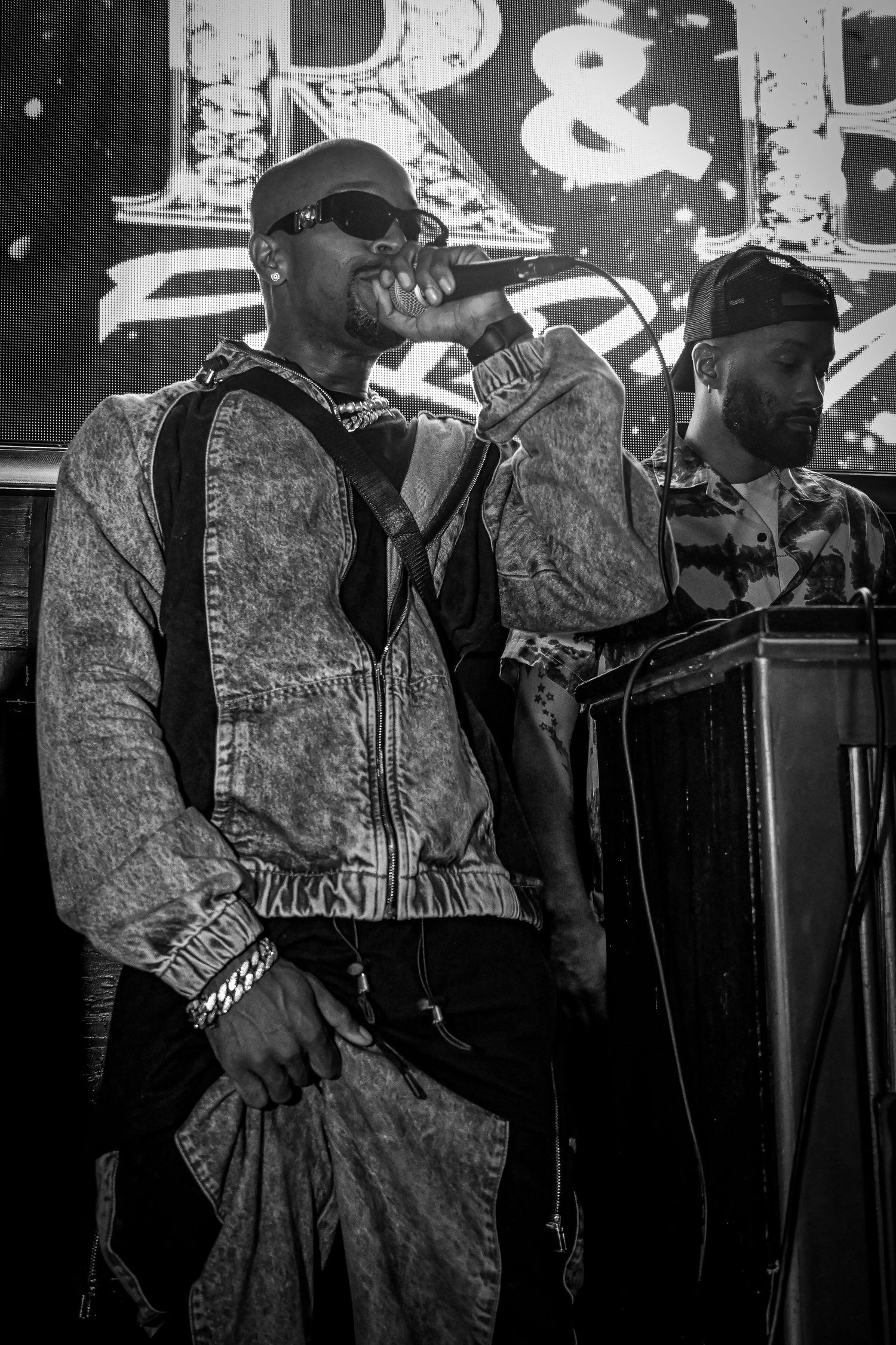 Black and white performance photos showing musicians on stage with microphones in a sequence of shots.