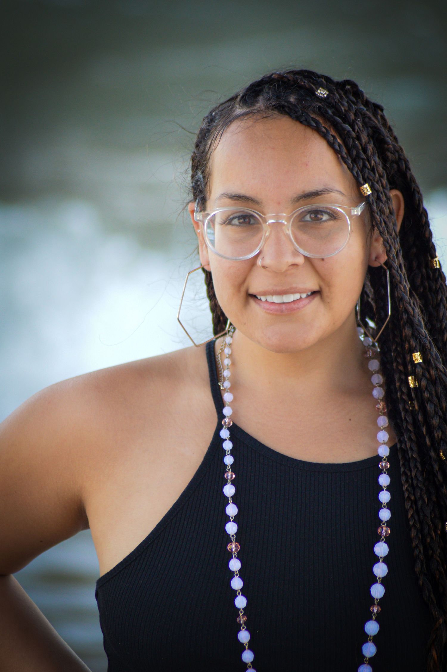 Portrait series showing a person in a black top with purple beaded hair accessories and glasses against a soft background.