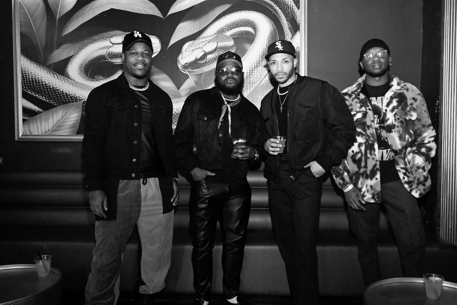 A black and white collage of hip hop artists performing and posing together in various settings.
