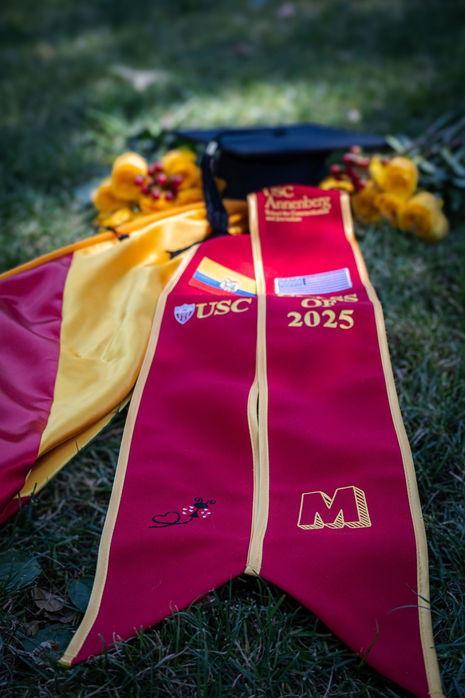 USC graduation sash with class of 2025 text lying on grass.