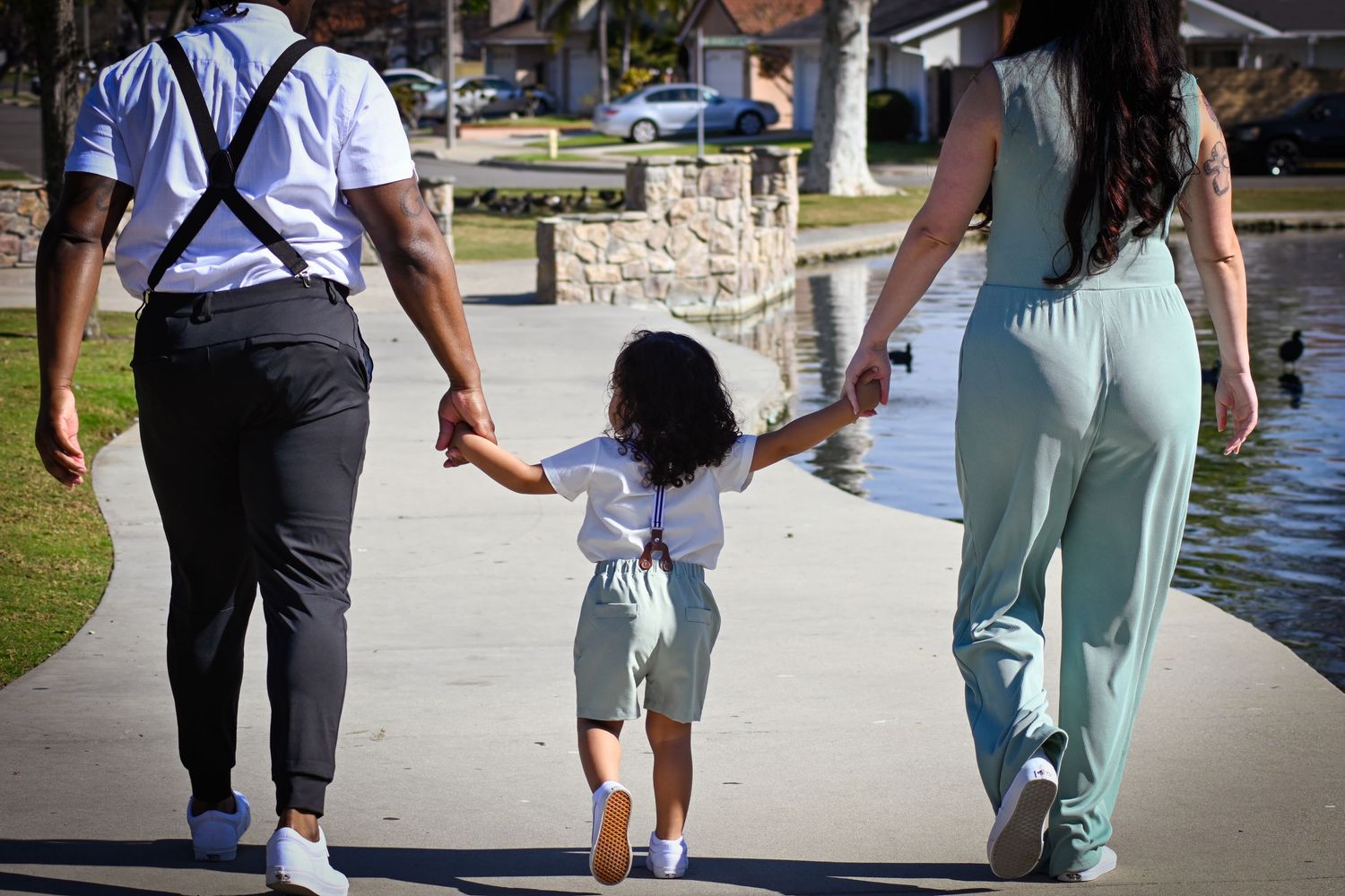 Two people walking together outdoors on a sunny day holding hands and enjoying a stroll.
