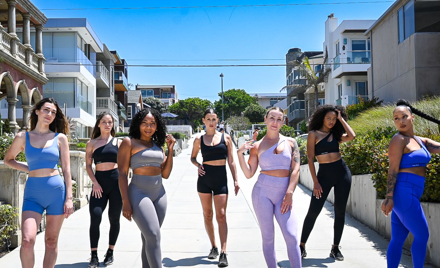 Group of people walking together outdoors in athletic wear during a fitness activity on a sunny day.
