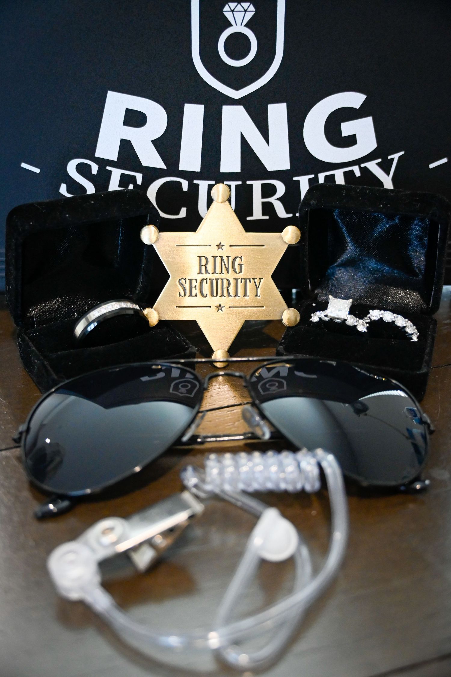 Ring Security badge, sunglasses, wedding rings, and earpiece displayed in a spy-themed ring bearer gift set.
