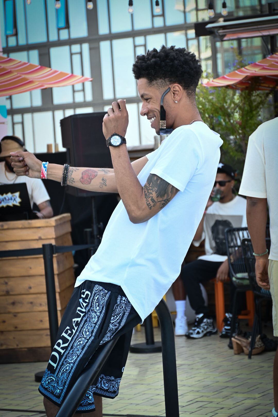 A sequence of dance moves showing a person in a white shirt and black bandana pants performing on a paved outdoor area.