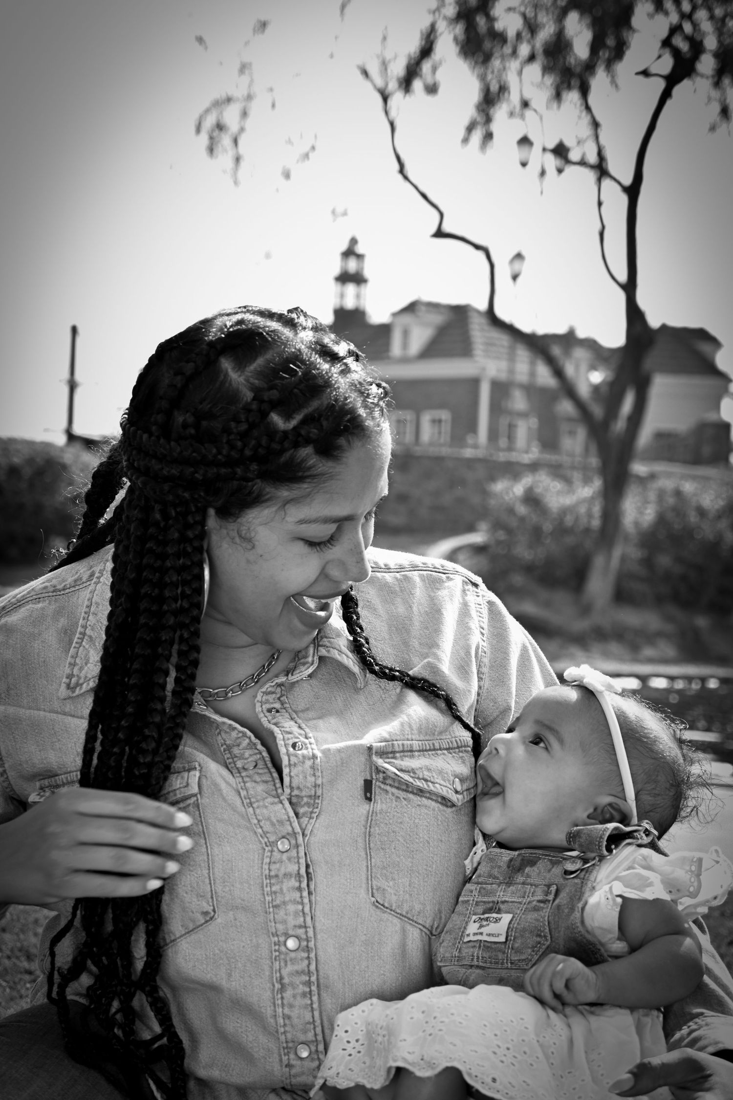 A series of black and white photos showing tender moments between a parent and baby outdoors.