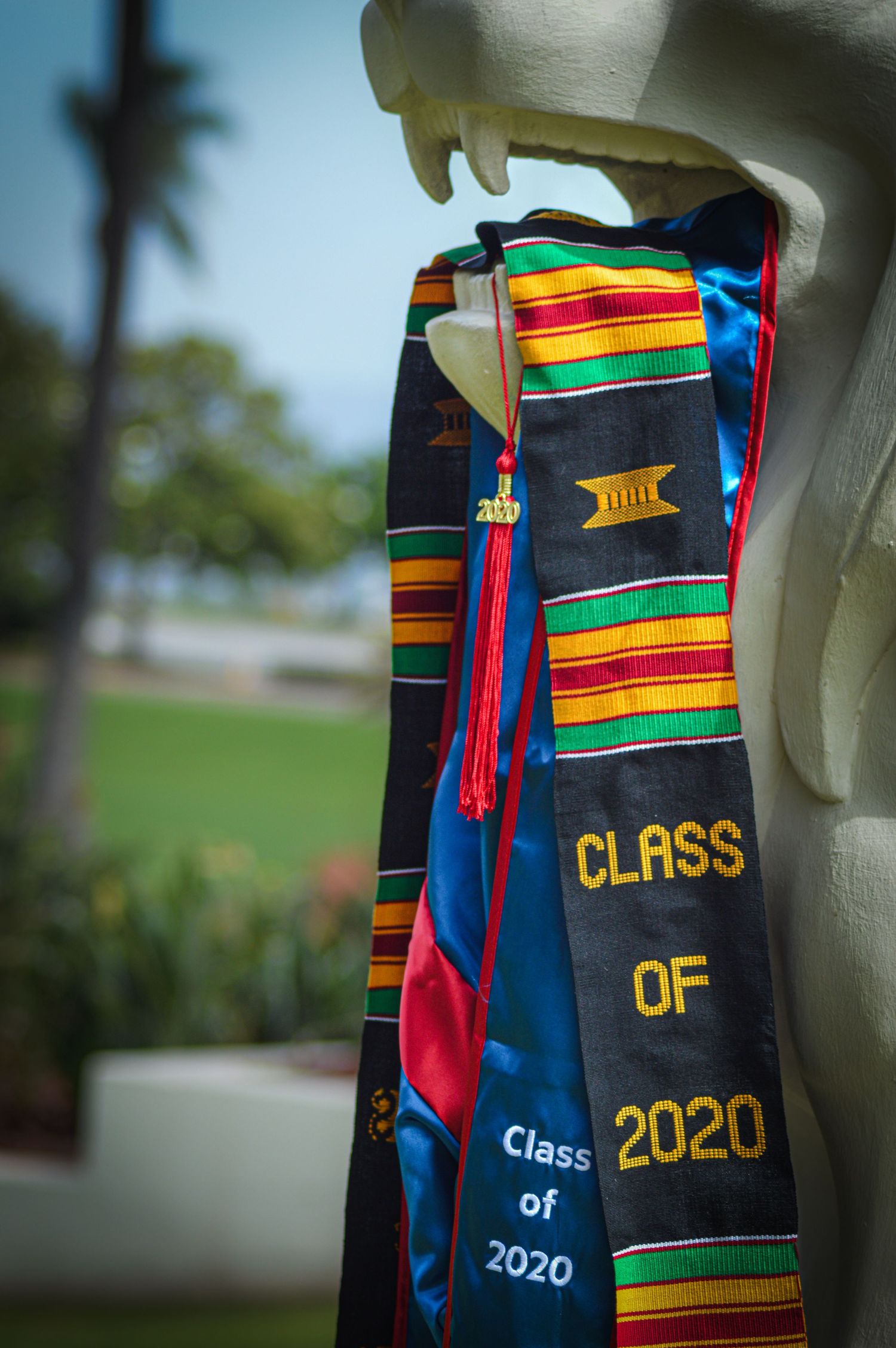 Graduation stoles and sashes decorated with Class of 2020 text and colorful kente cloth patterns.
