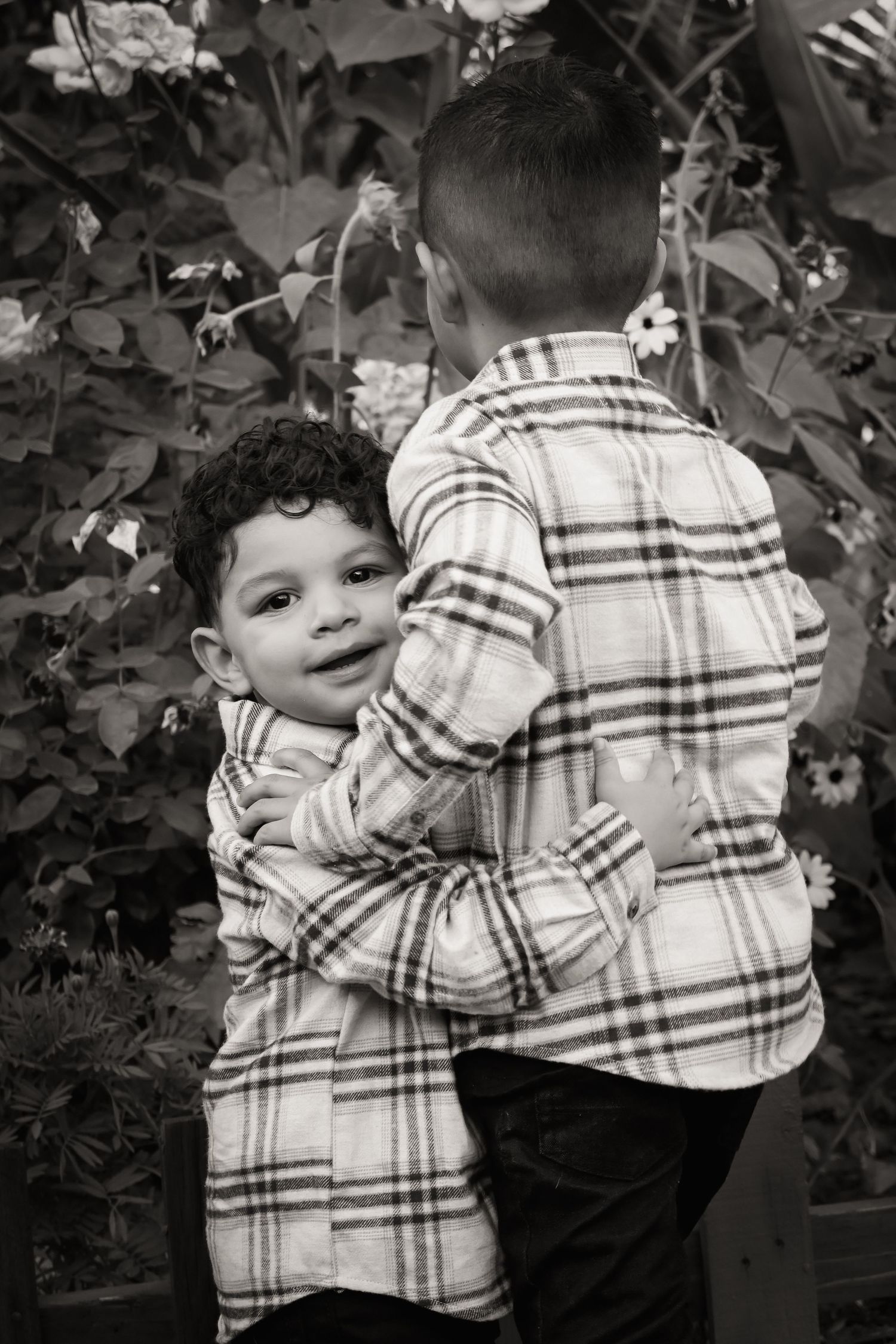 A sequence of black and white photos showing a small child in a plaid shirt playing outdoors.