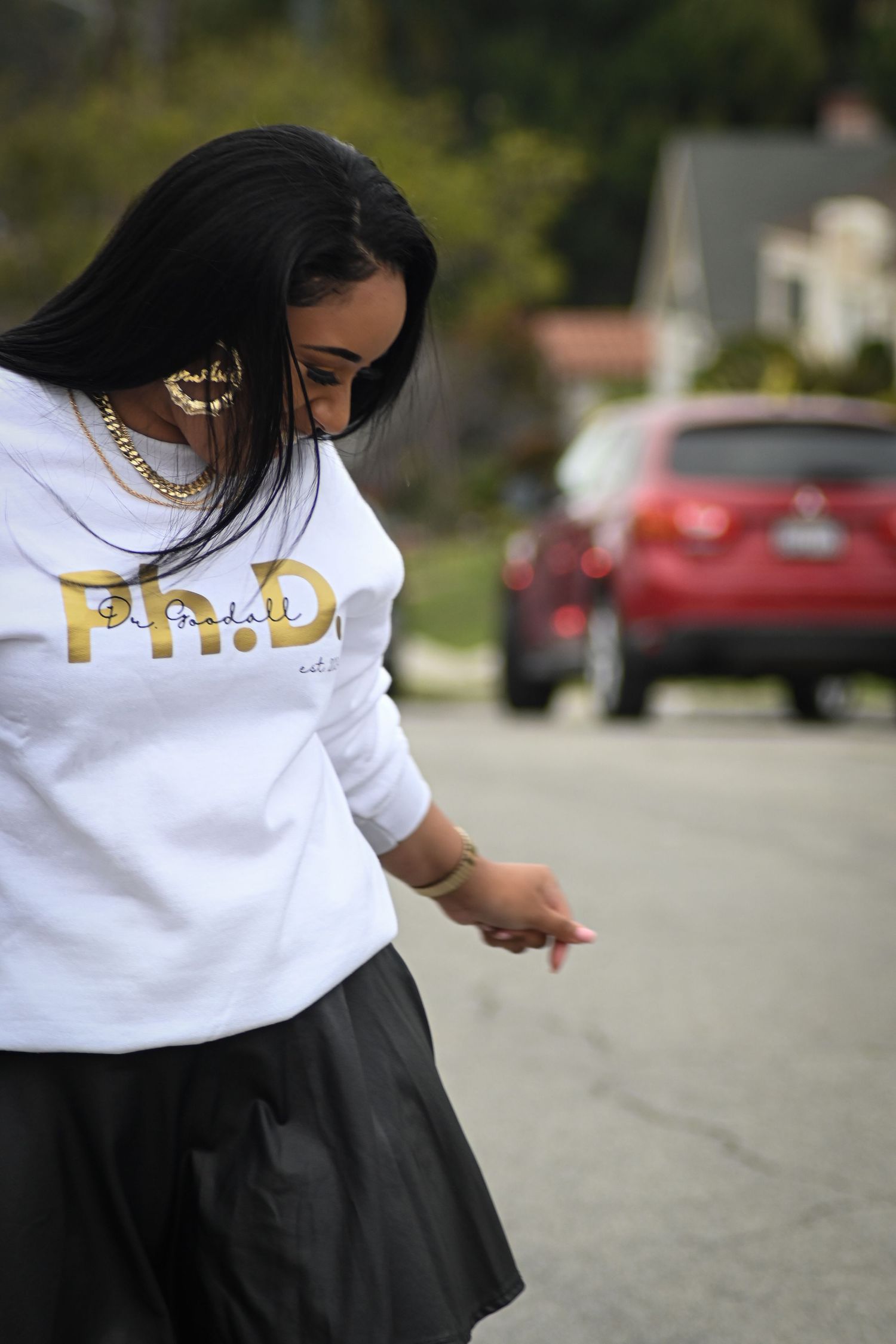 Close-up detail of gold text on a white sweatshirt during an urban photoshoot.