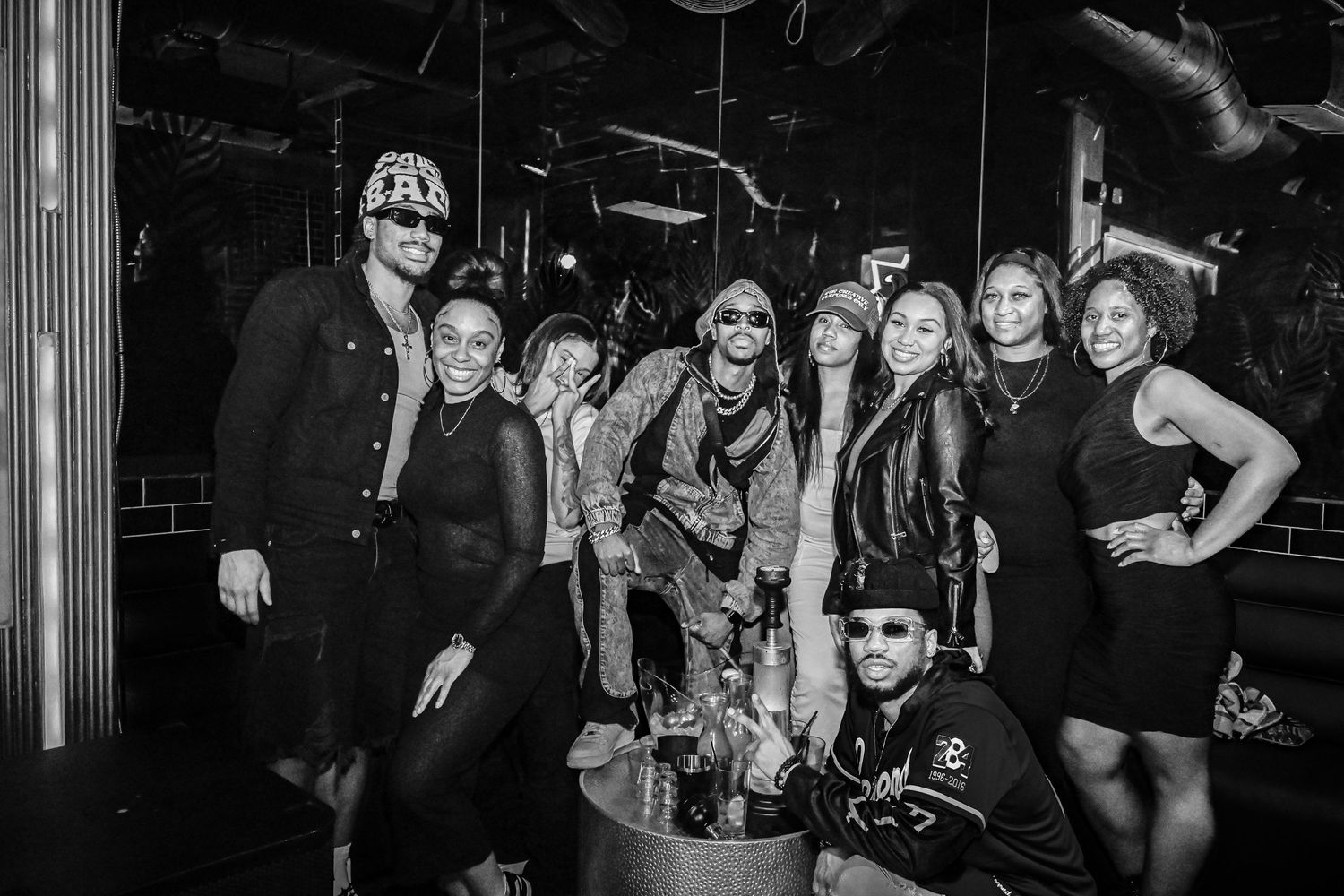Group of people enjoying a night out at what appears to be a bar or club venue with dark lighting.