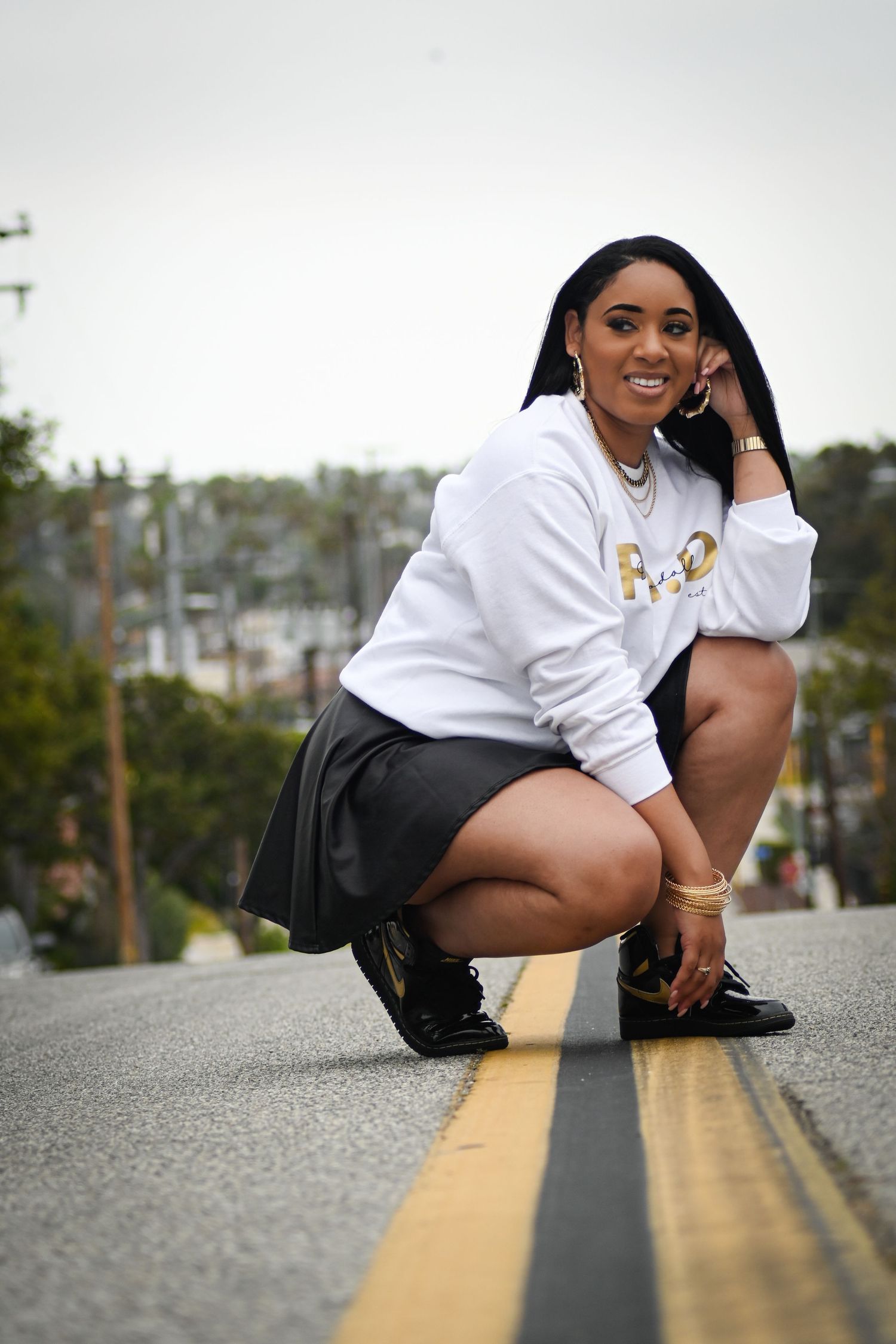 Urban fashion photo showing a casual pose near a yellow street marking.