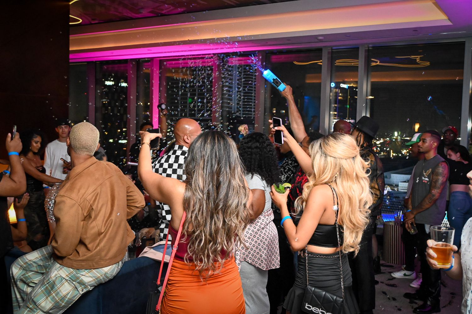 Nightclub party atmosphere with colorful lighting and people enjoying themselves on the dance floor.