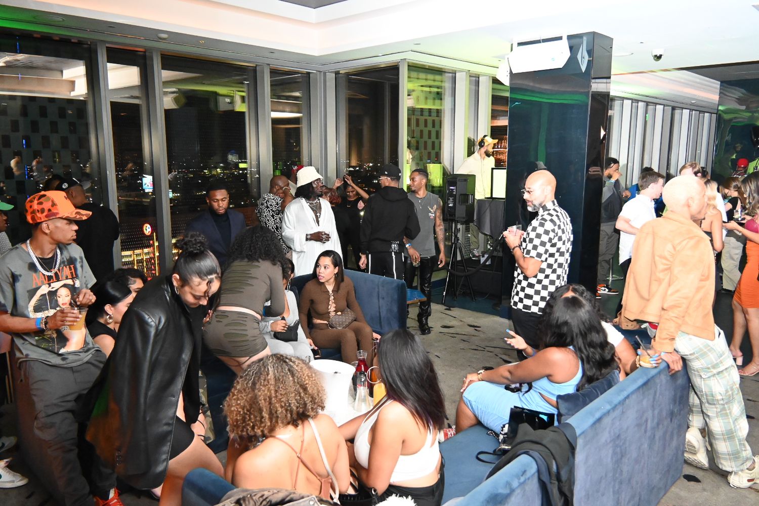 Crowd of people gathered outside glass doors waiting in line at a building entrance.