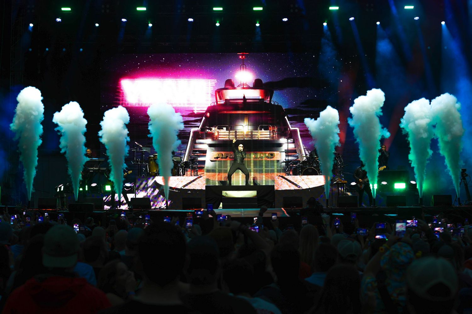 Professional concert photography by Dreamworx Studios featuring Pitbull performing on a stage with large smoke plumes and a massive LED