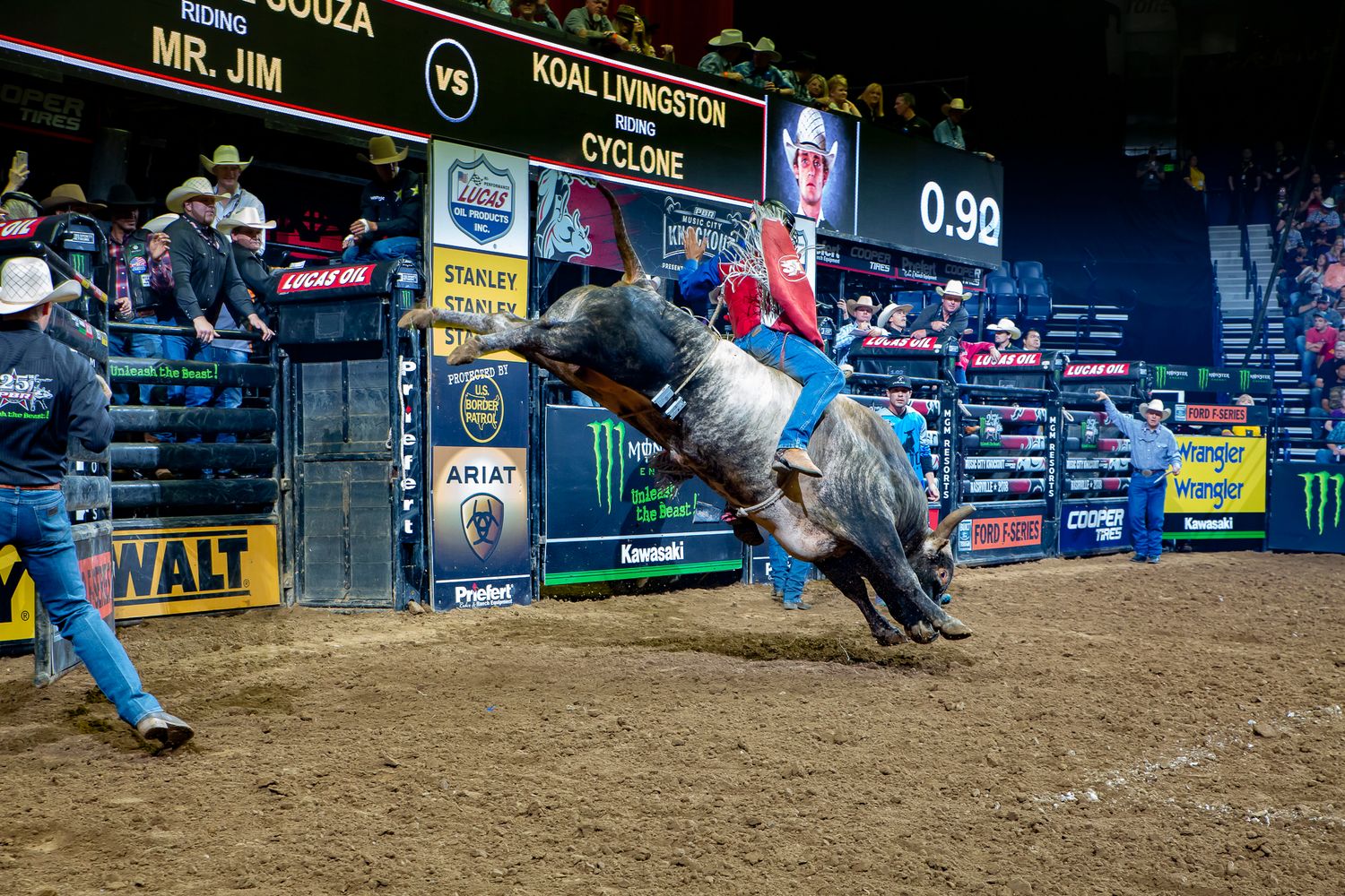 Bull rider attempts to stay mounted on bucking bull during intense rodeo competition.