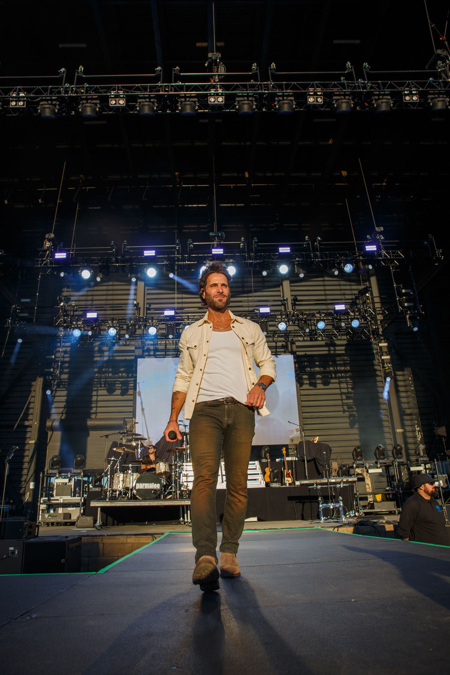 Dark concert stage setup with professional lighting rigs and equipment visible. Matt of Parmalee, CCMF