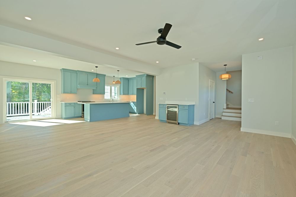 Open living room with natural light, wood floors and a fireplace