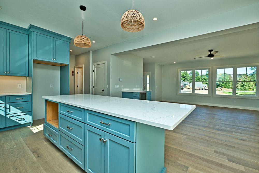 Blue kitchen cabinetry and a bright open interior photographed by Realty Shots